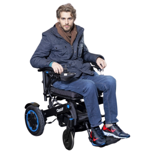 輪椅王 一名淺棕色頭髮和鬍鬚的男子坐在 Sunrise Quickie Q50R 電動輪椅上，身穿藍色夾克、棕色圍巾、藍色牛仔褲以及紅藍色運動鞋。