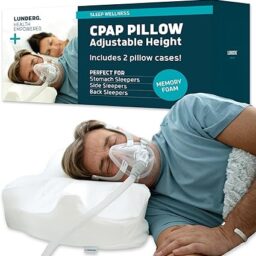 【輪椅王】 一名男子側睡，使用 Lunderg CPAP 呼吸機，面罩連接到 CPAP 機器。他身後的產品包裝上寫著“CPAP 枕頭可調節高度”，並表明它包括兩個枕頭套。適合各種睡姿。