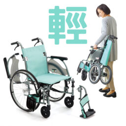 【輪椅王】 一名婦女拿著折疊的輕型輪椅。本產品為日本品牌Miki CRT-3/MOCSW-43J(LK1)多功能手推輪椅(有淺綠色或藍色座背墊選擇)(輪椅王型號：SUPER LIGHT 22)，所示為組裝後和折疊。背景包括大字符