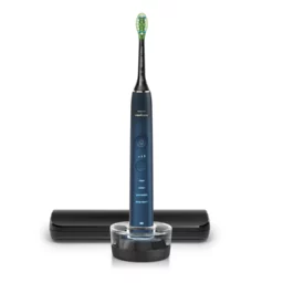 【輪椅王】 帶有綠色和白色鬃毛頭的黑色飛利浦 Sonicare 9000 系列電動牙刷立在充電底座上，後面有一個封閉的黑色旅行箱。