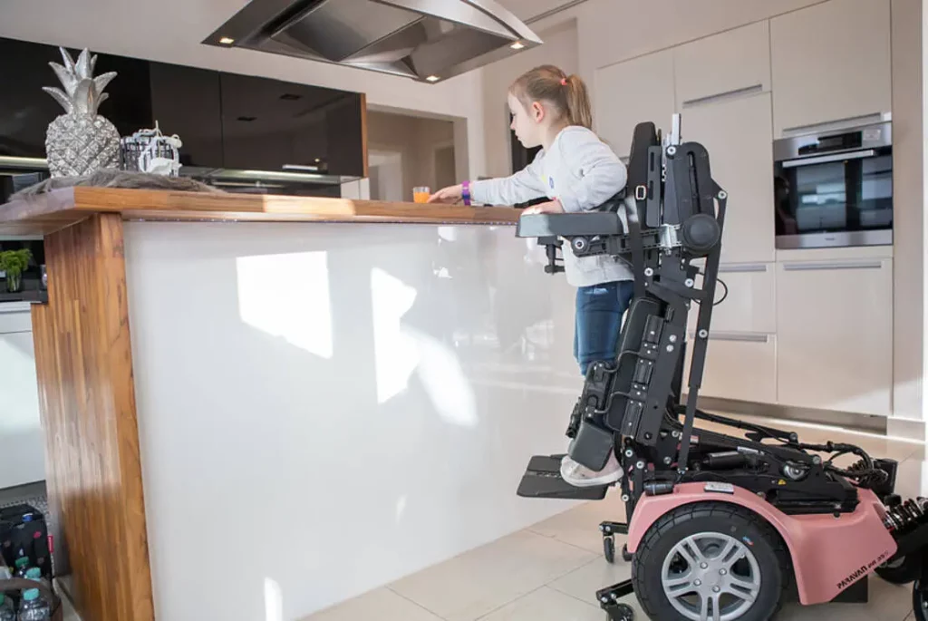 【輪椅王】 A child in a WCPR 35S Standing Electric Wheelchair effortlessly reaches for an item on the kitchen counter.